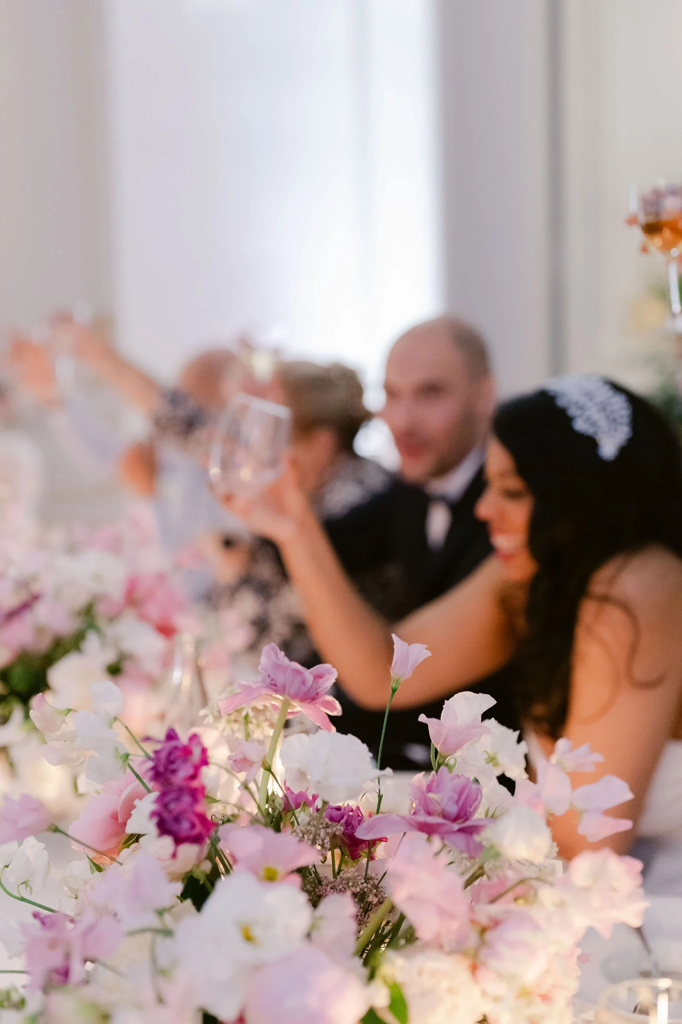 Wedding guests celebrating among pink floral arrangements