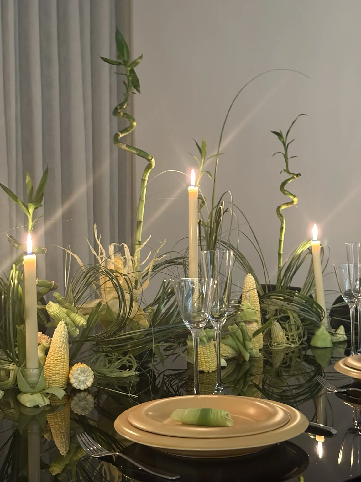 Editorial table with bamboo, green leaves, and candles