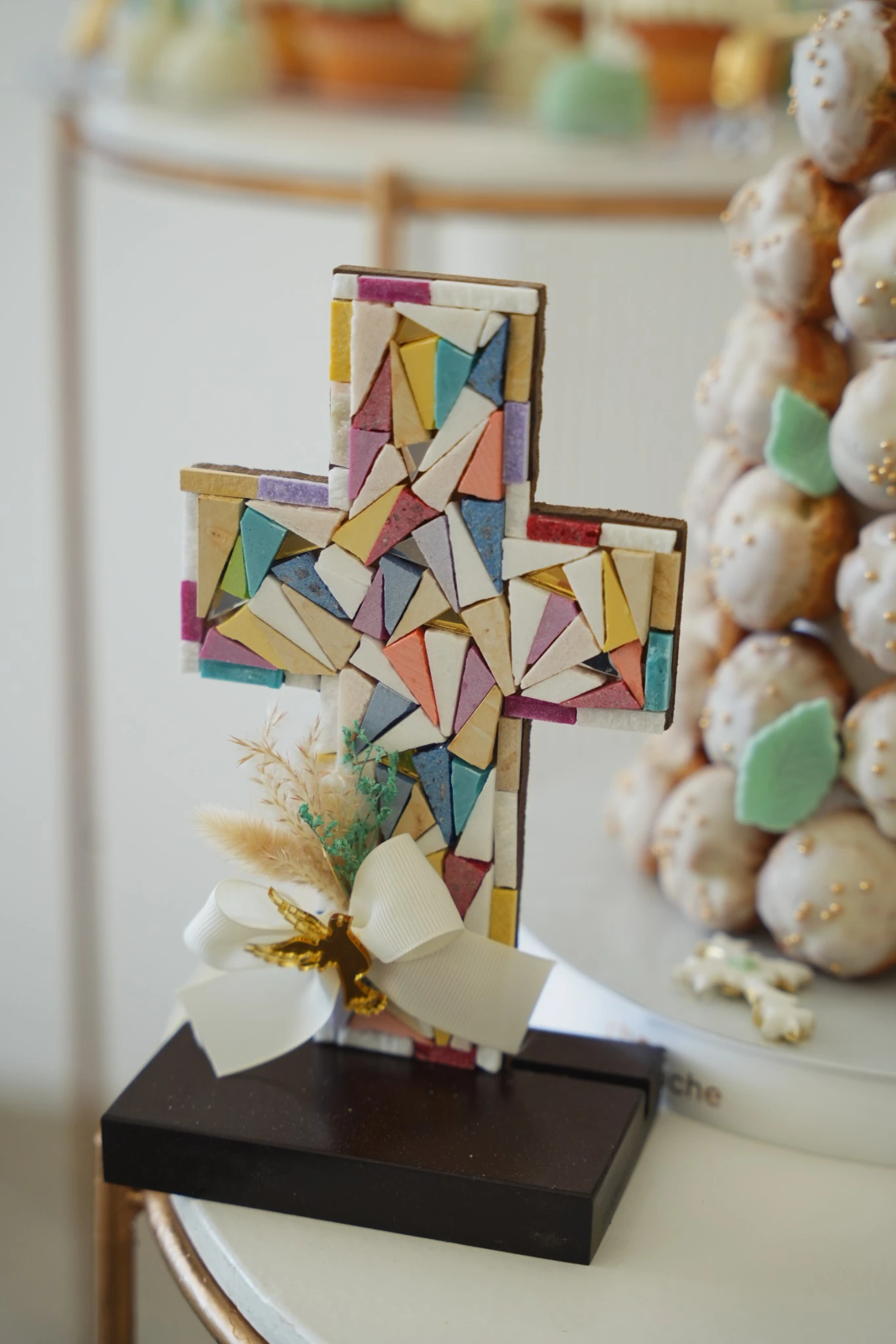 Colorful mosaic baptism cross and decorative sweets